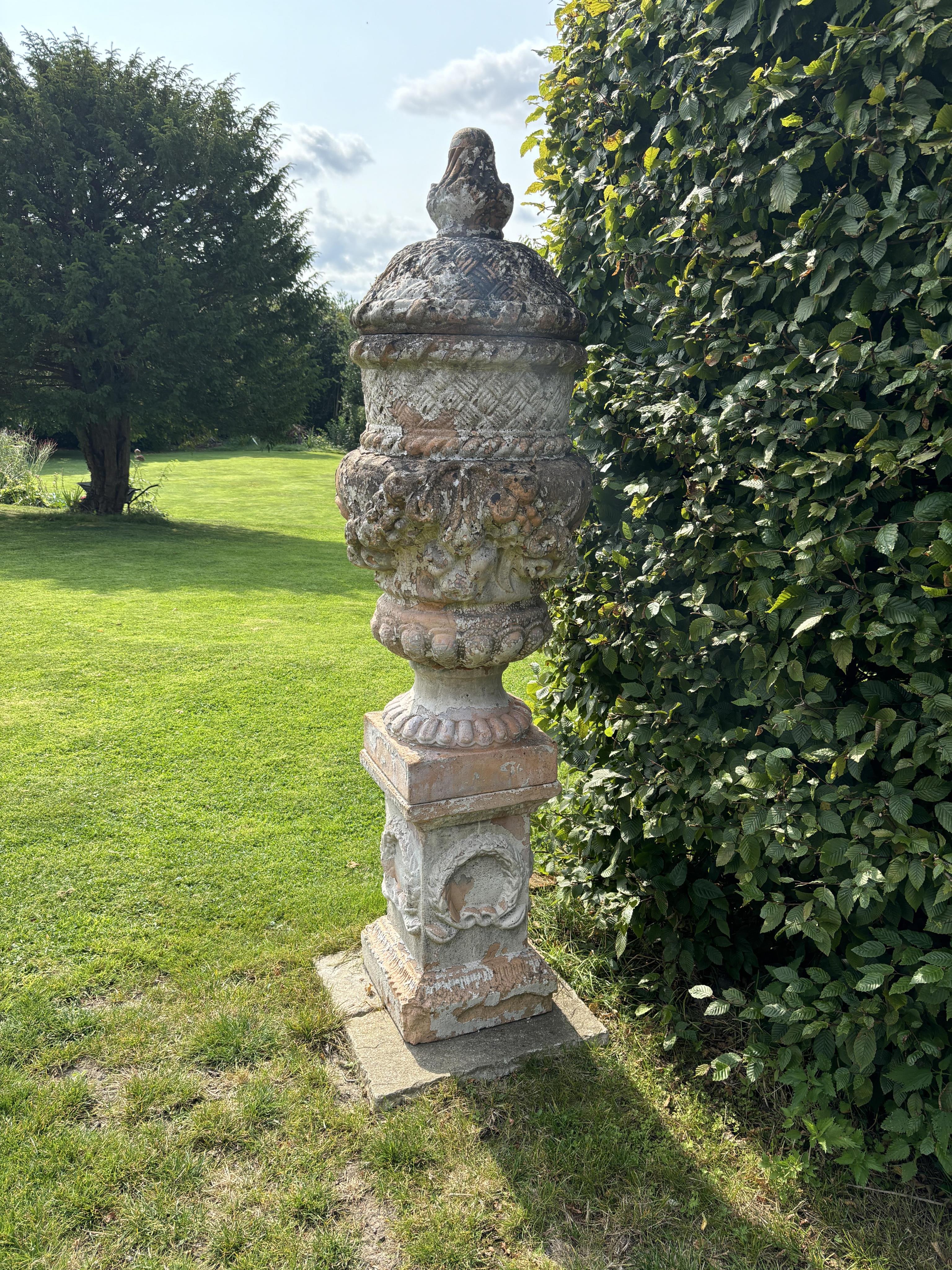 An Italian cream glazed terracotta garden urn on pedestal